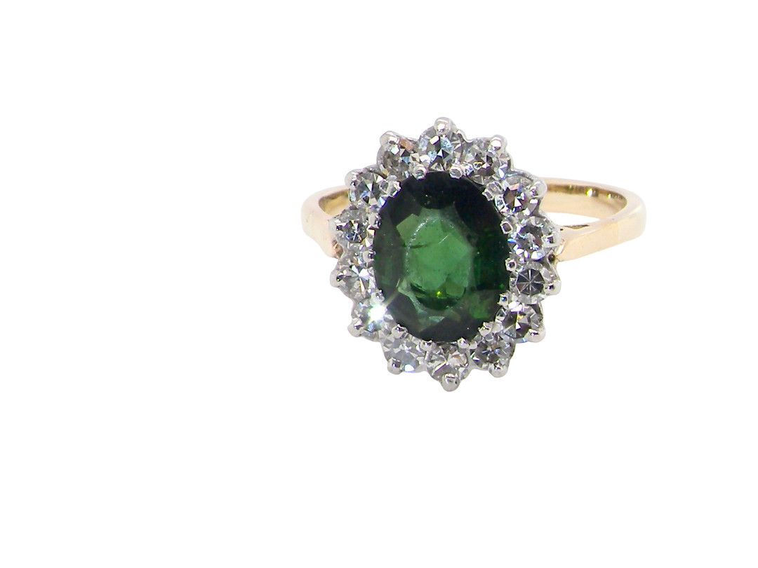 A fine and impressive vintage cluster ring, centred with a striking oval-cut deep dark green tourmaline, measuring 9 x 7mm and estimated to weigh  2.00 carats.