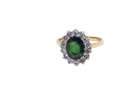 A fine and impressive vintage cluster ring, centred with a striking oval-cut deep dark green tourmaline, measuring 9 x 7mm and estimated to weigh approximately 2.00 carats.