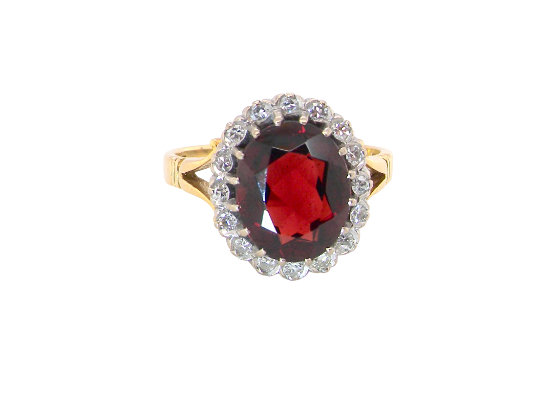 A fine cluster ring. Features a large garnet centre stone&nbsp;

Complimented by an outer halo of brilliant cut white diamonds.&nbsp;