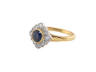 A fine cluster ring featuring to the centre a round dark blue sapphire, 5mm diameter (0.50 carats) 
