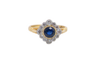 A fine cluster ring featuring to the centre a round dark blue sapphire, 5mm diameter (0.50 carats) mille grain setting.
