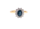 A fine cluster ring that features a black blue oval cut sapphire that measures 7x5mm 
