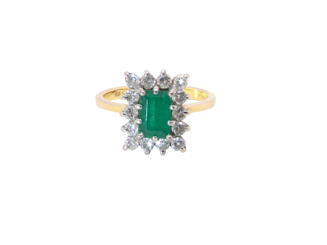 A fine cluster ring that features a rectangular mid to dark green emerald, measures 8x6mm (est 0.50 carats)&nbsp;

