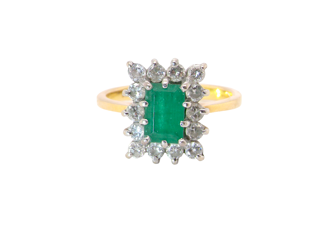 A yellow gold ring featuring a central emerald-cut green gemstone surrounded by a halo of small clear stones, set against a plain white background.