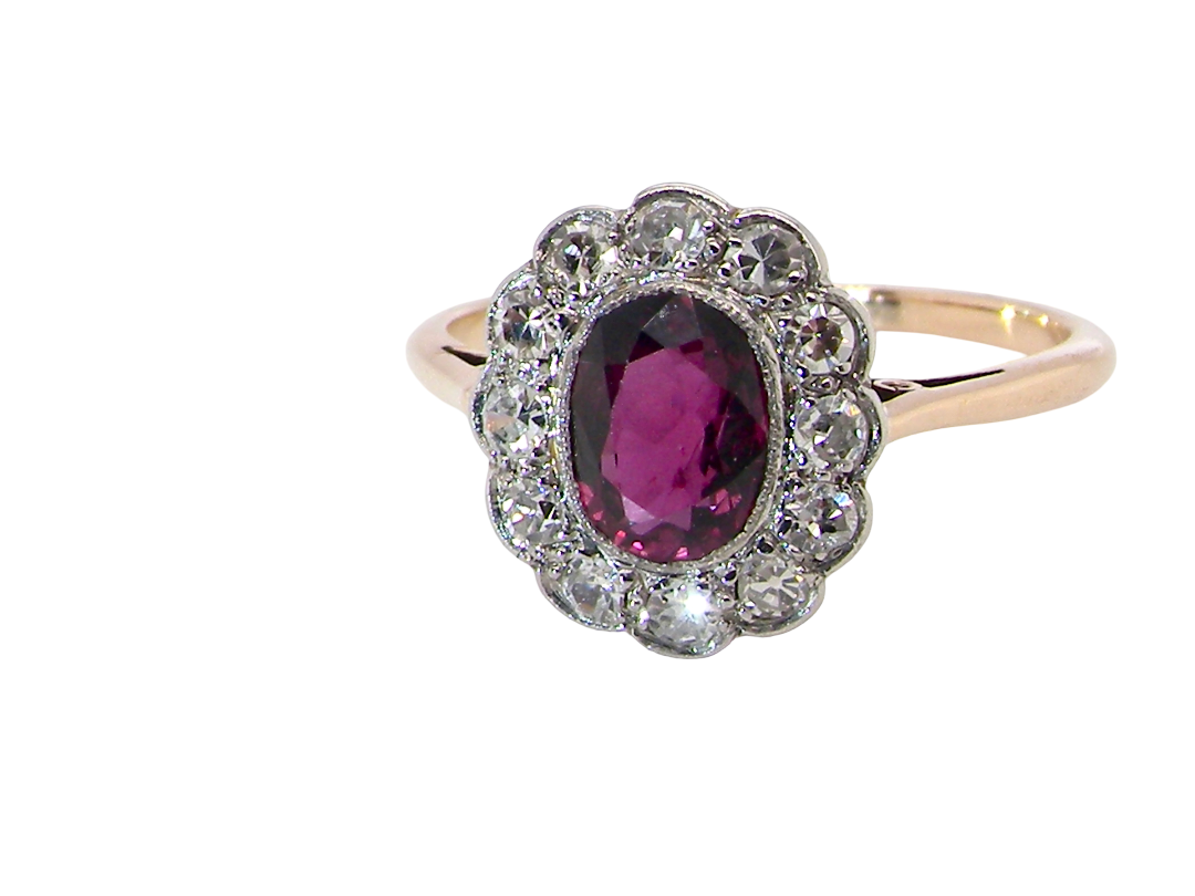 A fine early 20th century cluster ring featuring to the centre an oval ruby, 6x5mm, deep burgundy red colour, (est 1.02 carats)
