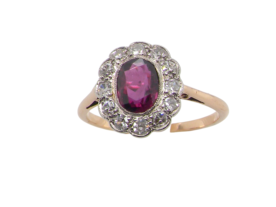 A fine early 20th century cluster ring featuring to the centre an oval ruby, 6x5mm, deep burgundy red colour, mille grain setting.

