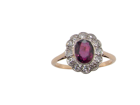 A fine early 20th century cluster ring featuring to the centre an oval ruby, 6x5mm, deep burgundy red colour, mille grain setting. (est 1.02 carats)
