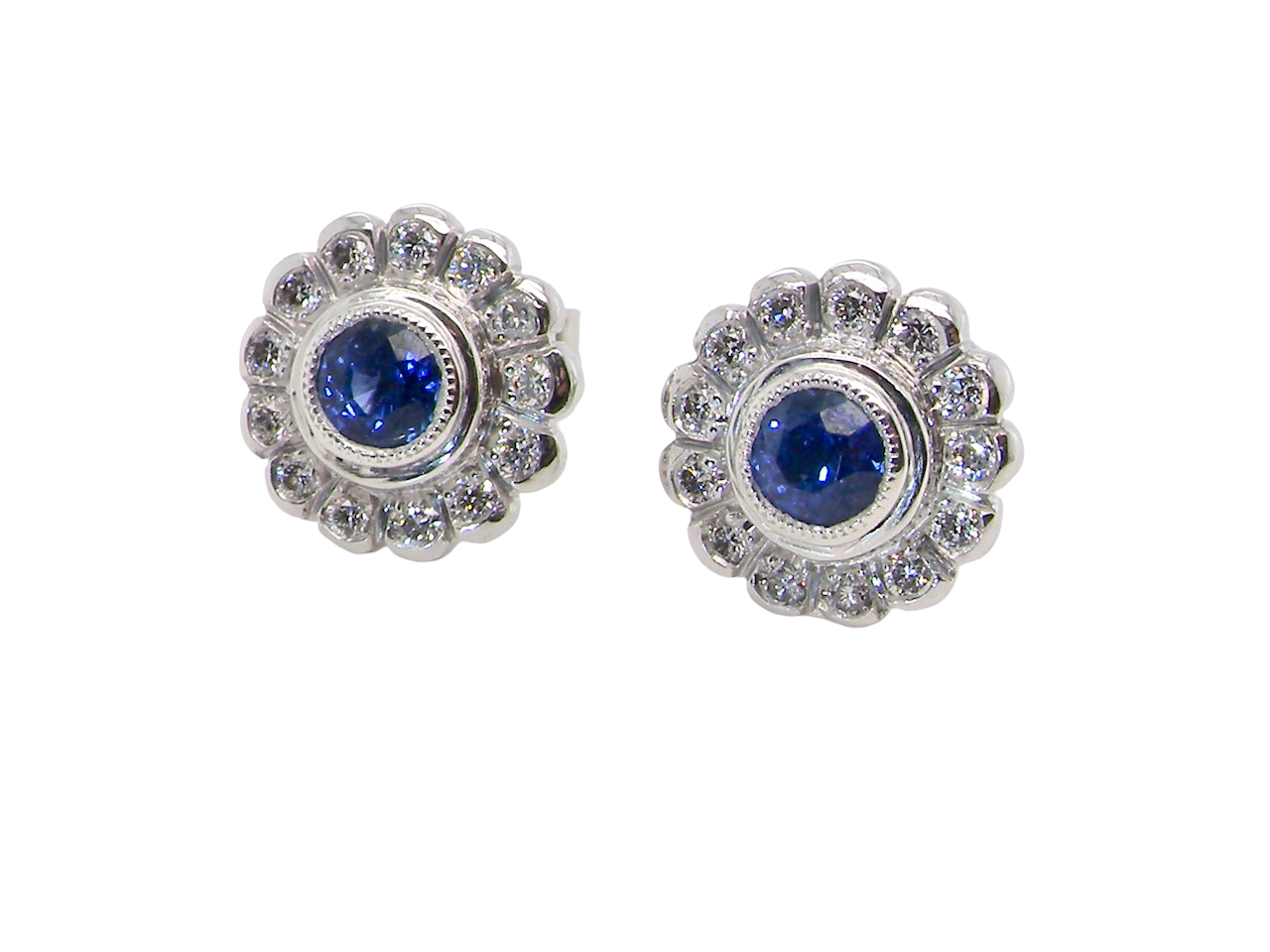  A fine pair of 18 carat white gold sapphire and diamond cluster earrings.

Each earring is set with a central round sapphire measuring approximately 3.4mm in diameter,