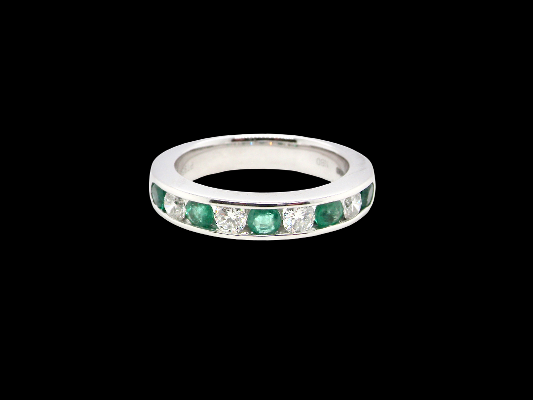 A fine platinum half hoop eternity ring. This is a new ring*. Channel set gem stones, five bright green emeralds 2.6mm each