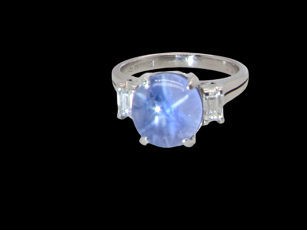 A fine platinum* ring. Features a lovely sky blue sapphire with 'star sapphire ' chatoyancy , measures 10x9mm, (est 4 carats)  cabouchon cut