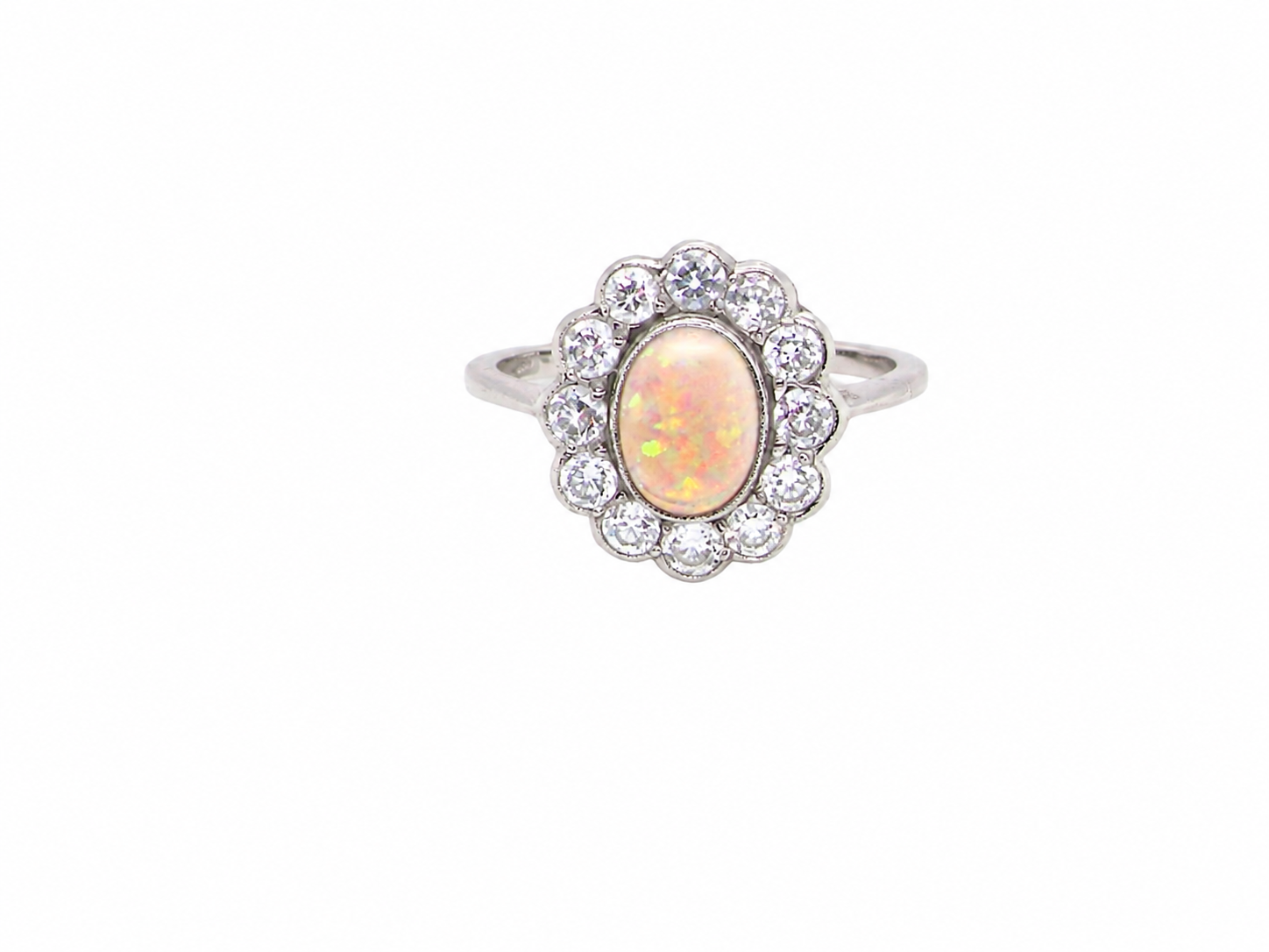 A fine vintage cluster ring. Features to the centre an oval shaped opal, with excellent play of colour, pink to one way, vibrant green to the other with flashes of electric blue also within the body of the gem.
