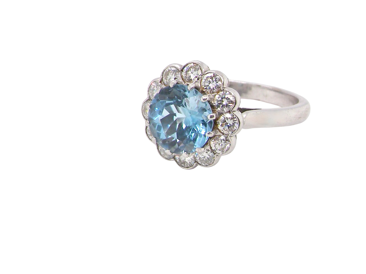 A fine vintage cluster ring centred with a deep blue aquamarine, measuring approximately 8mm  2 carats, securely claw set.