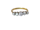 A yellow gold five-stone diamond ring with a graduated round diamond setting, shown on a plain white background.