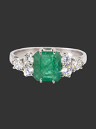 A fine white gold* ring that features a rectangular emerald centre stone, measures 6x6.5mm (est one carat), 