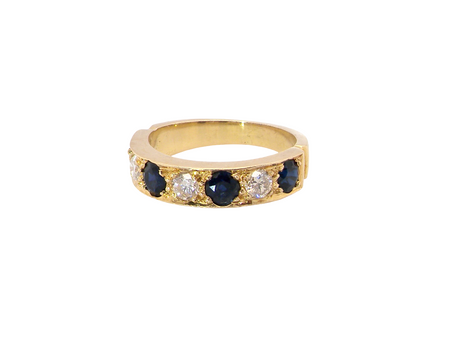 A half hoop ring. Features four dark ink blue black sapphires, each 3.6mm, and three brilliant cut white diamonds, each 3.6mm (est 0.15-0.17 carats each, total 0.50 carats est)

