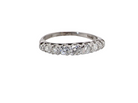 A diamond eternity ring with a row of round-cut diamonds set in a polished band, shown on a plain white background.