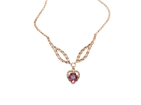 A late 1970s pendant/necklace. Features a heart shaped pendant that has a cluster set to its centre. Six small rubies 2.3mm each surround an illusion set diamond. Diamond cut outer rim.

