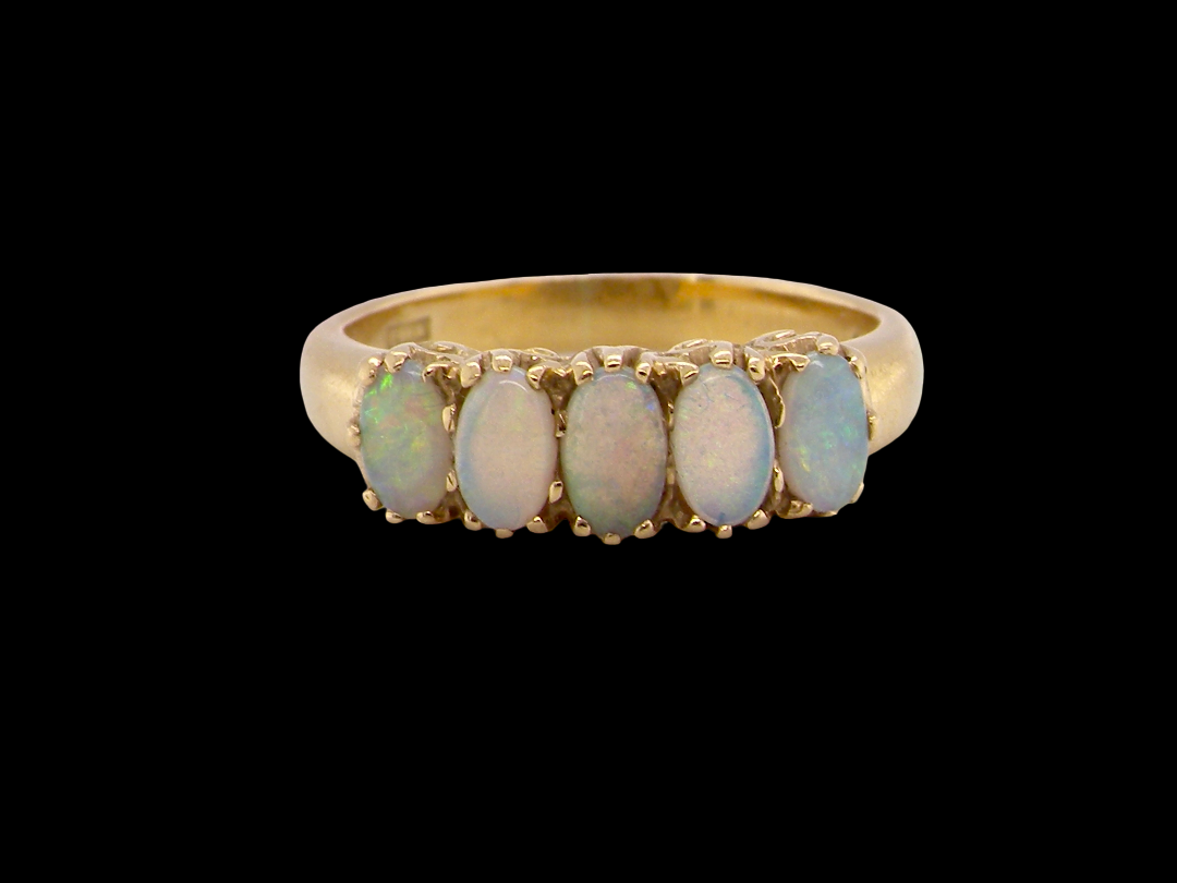 A lovely five stone ring. Set with five oval white opals, each 5x3.5mm, good play of colour on all.

