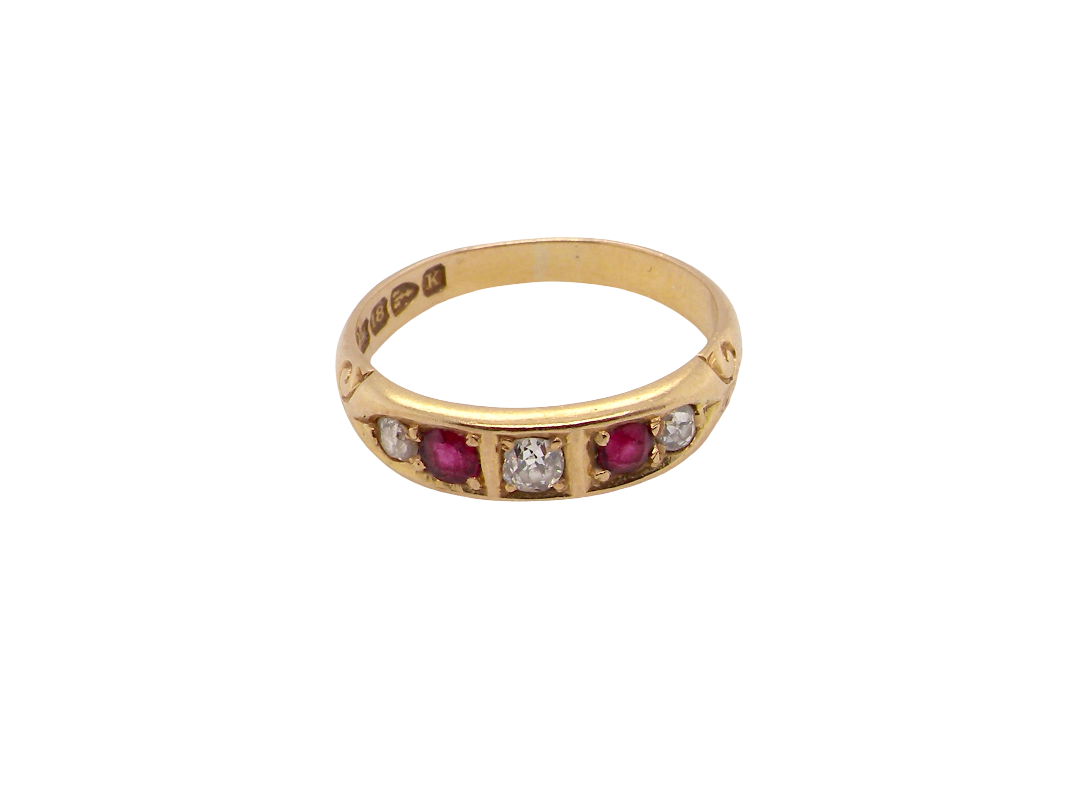 A vintage yellow gold ring featuring a row of round-cut pinkish-red rubies and clear diamonds, shown on a plain white background.