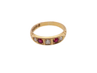 A vintage yellow gold ring featuring a row of round-cut pinkish-red rubies and clear diamonds, shown on a plain white background.