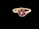 A modern 9 carat gold cluster ring. At the centre a small diamond, this complimented by an outer halo of six 2.4mm rubies