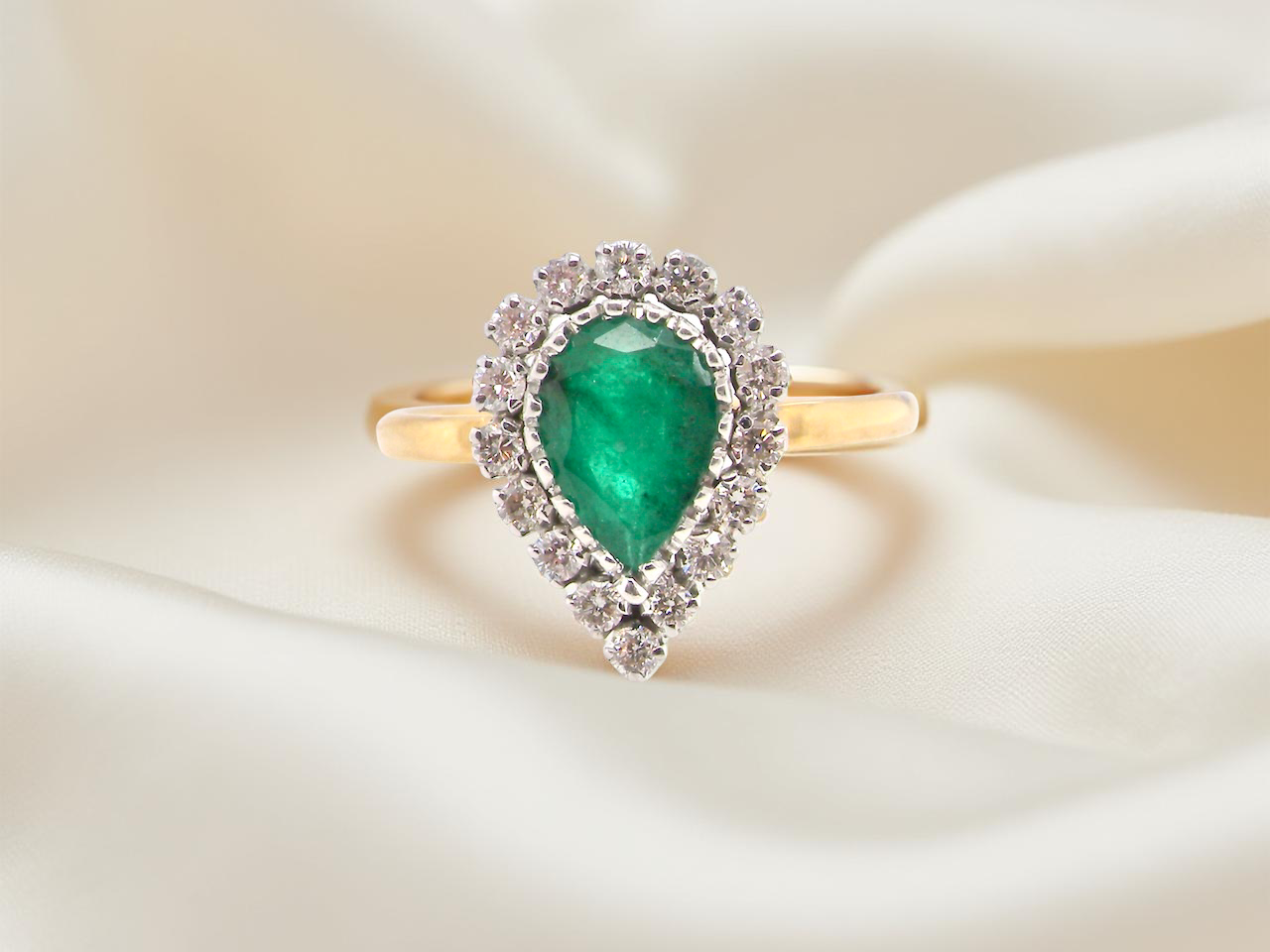 A pear shaped Emerald and Diamond cluster ring