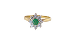 A pretty 18 carat gold cluster ring. The centre stone is a round emerald 4mm diameter (0.25 carats) mid green colour.
