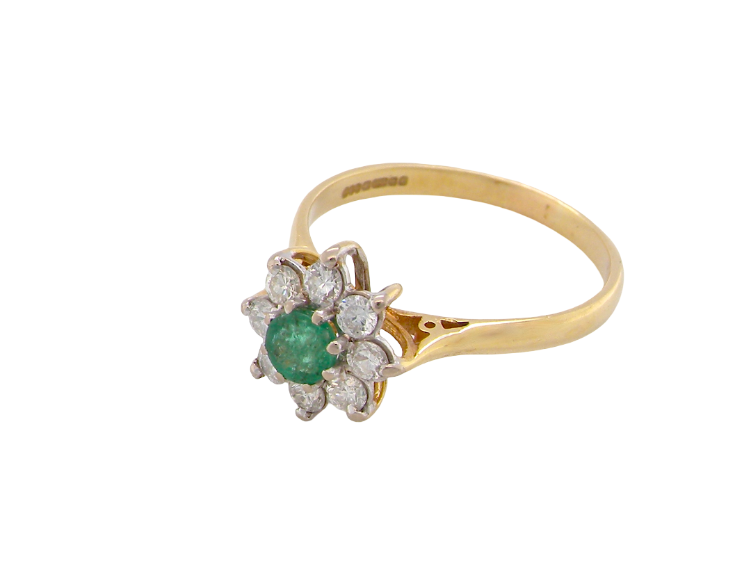 A vintage yellow gold ring featuring a central round green emerald gemstone surrounded by a halo of small round clear diamonds, set on a plain white background.