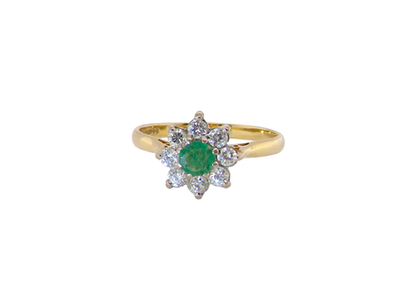 An emerald and diamond cluster ring