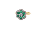 A pretty cluster ring. Features emeralds and diamonds. Centre stone a brilliant cut white diamond, measures 4mm 