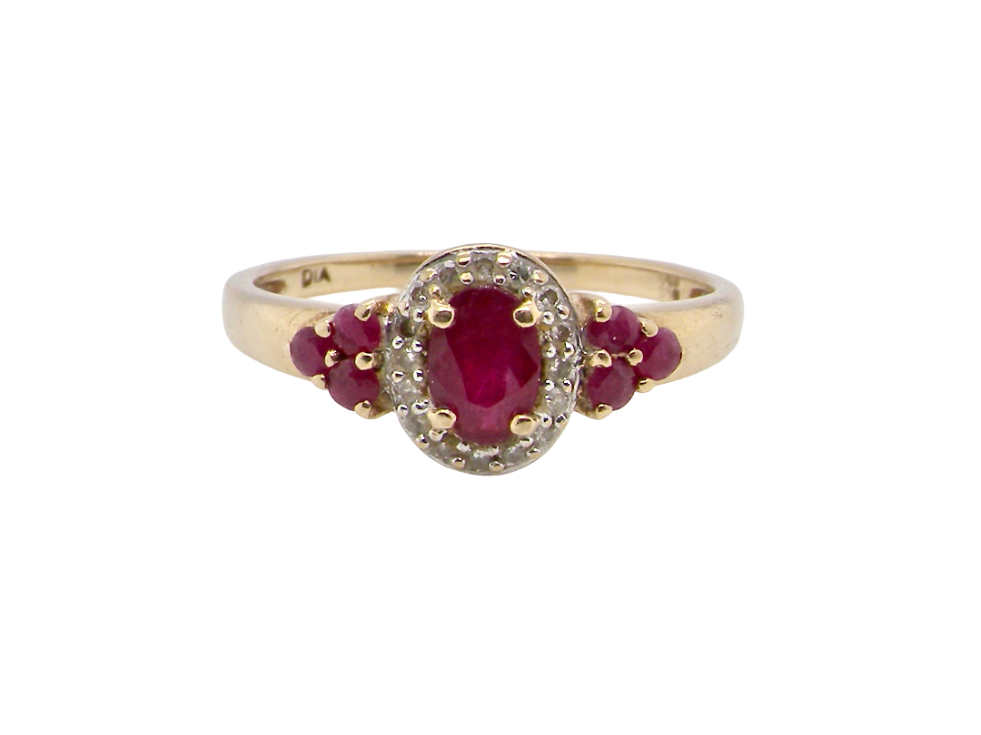 A pretty cluster ring that features to the centre an oval cut ruby, 5x4mm, retained by four claws and an outer halo of sixteen small white diamonds, each 1.3mm 