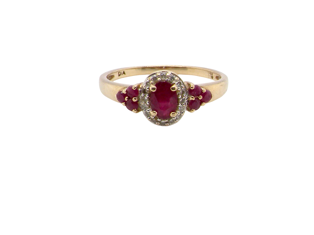 A pretty cluster ring that features to the centre an oval cut ruby, 5x4mm, retained by four claws and an outer halo of sixteen small white diamonds, each 1.3mm (total estimated at 0.15 carats)&nbsp;
