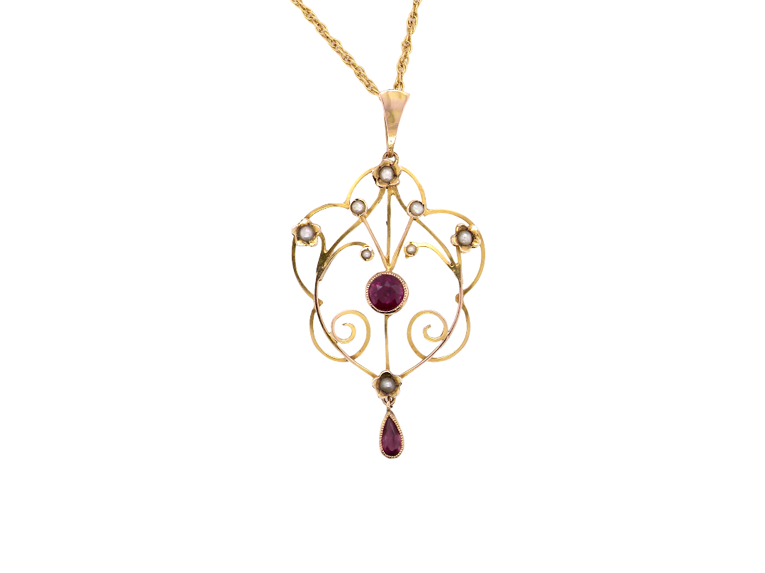 A pretty early 20th century pendant. Openwork design with a round garnet to the centre, measures 5.6mm, mille grain setting.