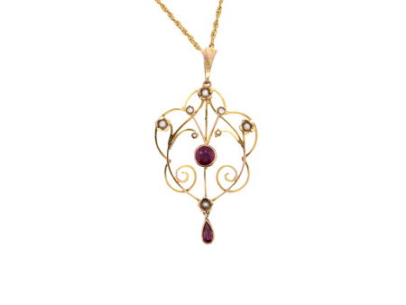 A pretty early 20th century pendant. Openwork design with a round garnet to the centre, measures 5.6mm, mille grain setting.