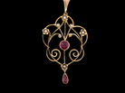 A pretty early 20th century pendant. Openwork design with a round garnet to the centre, , mille grain setting.