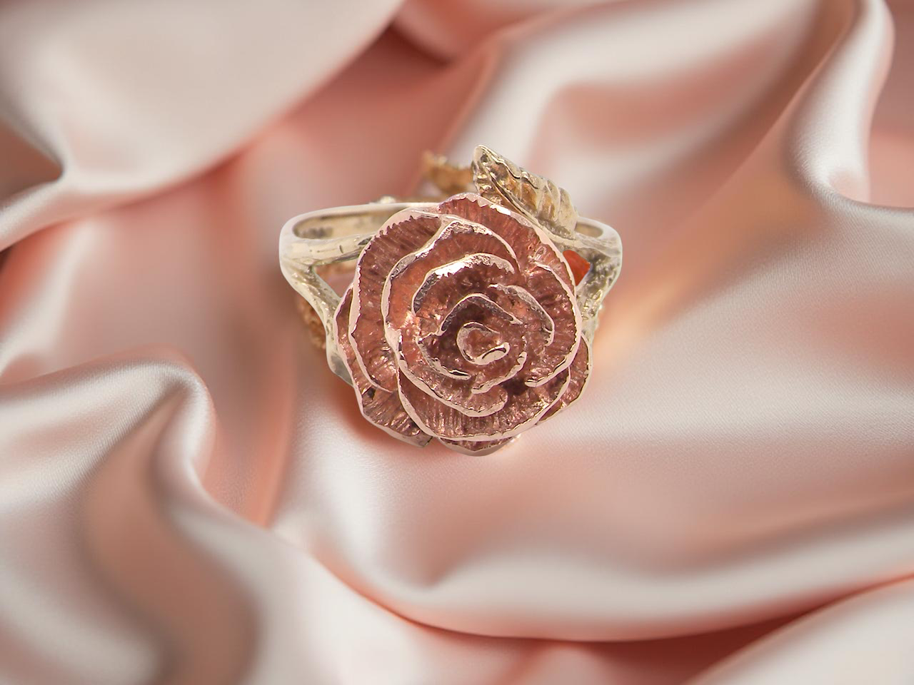 Rose gold ring on a soft pink fabric background