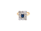 A rectangular cluster ring that features in its centre a cushion shaped dark blue sapphire, that measures 5x3.5mm (est 0.30 carats)