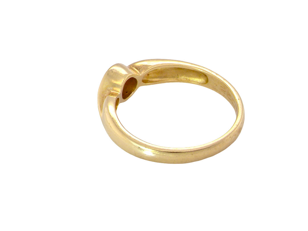 A polished yellow gold ring with a unique, organic curved shape and a circular cutout detail on the top, shown against a plain white background.