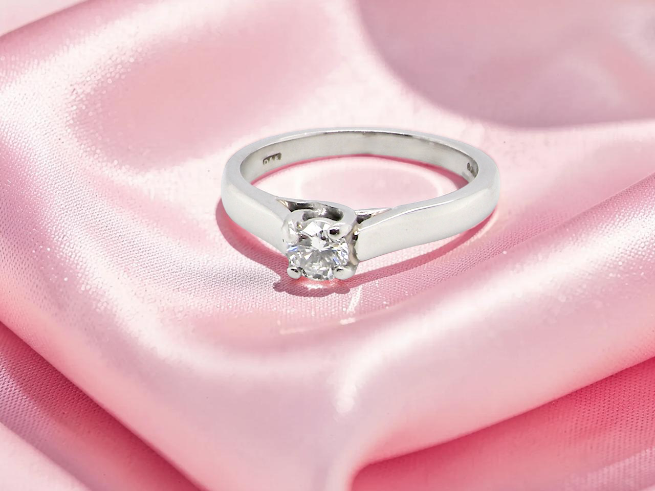 A single stone solitaire diamond ring. The modern brilliant cut white diamond measures 3.9mm (0.22 carats est) 