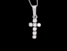 A small cross pendant in &nbsp;18 carat white gold, set with&nbsp; 7 brilliant-cut white diamonds.