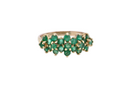 A striking and unusual dress ring, designed with multiple clusters of round-cut emeralds set beautifully across the finger for a bold,  look.