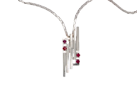 A striking modern pendant set with four 3mm rubies. The pendant measures approximately 40mm x 14mm and features a sleek design of five horizontal bars, with the outer bars each set with vibrant round rubies.