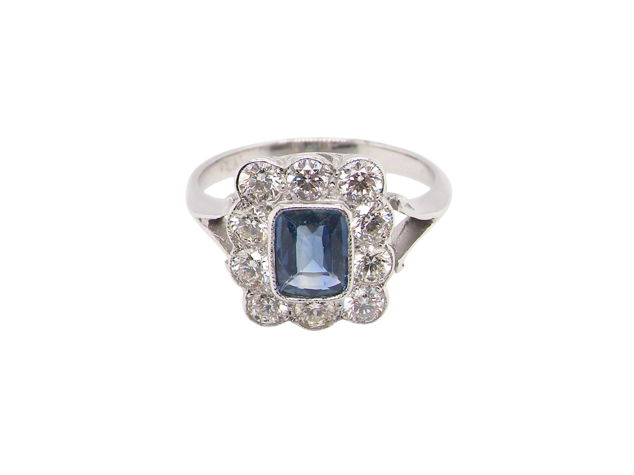 An Art Deco cluster ring featuring a rich mid- to dark ink-blue sapphire,