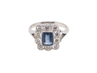An Art Deco cluster ring featuring a rich mid- to dark ink-blue sapphire,