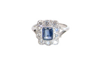 A stunning Art Deco cluster ring featuring a rich mid- to dark ink-blue sapphire,