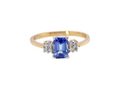 A three stone 18 carat gold ring. Features a rectangular tanzanite centre stone 6x4mm (