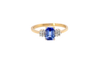 A three stone 18 carat gold ring. Features a rectangular tanzanite centre stone 6x4mm (est 0.50 carats)