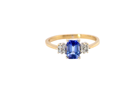 A three stone 18 carat gold ring. Features a rectangular tanzanite centre stone 6x4mm (est 0.50 carats)