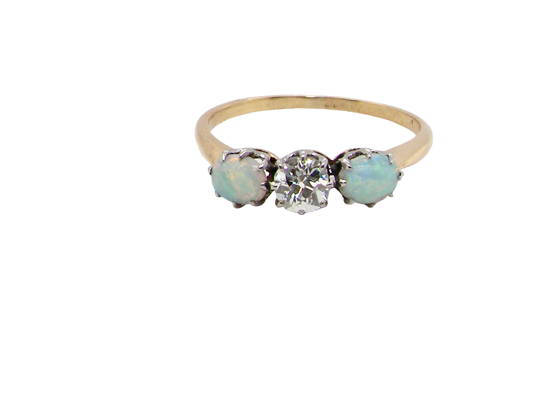 A three stone ring, the centre stone an old brilliant cut white diamond 4.6mm (est 0.38 carats) colour i-j, clarity Si, claw set in platinum.opal