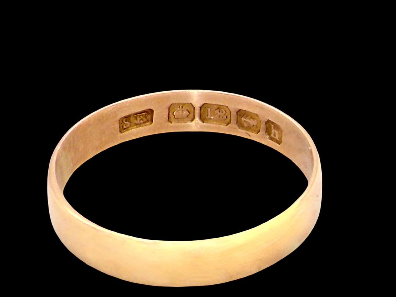 A traditional 18 carat gold wedding ring.

A flat to a slight D shape profile, width 3.6mm. 
